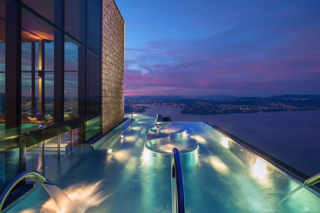 The infinity pool at the Bürgenstock Alpine Spa just after sunset