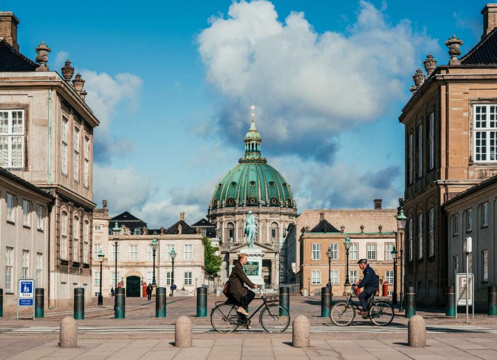 Cyclists pass Amalienborg Palace